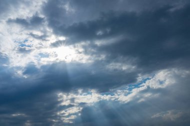 Bulutlar ve güneş ışınlarıyla dramatik mavi gökyüzü. Akşam günbatımında güneş ışınları..