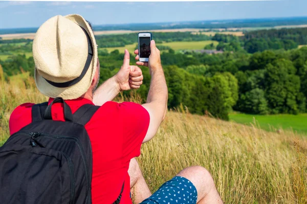 Młody Backpacker Człowiek Biorąc Selfie Zdjęcie Pomocą Smartfona Pokazując Kciuk — Zdjęcie stockowe