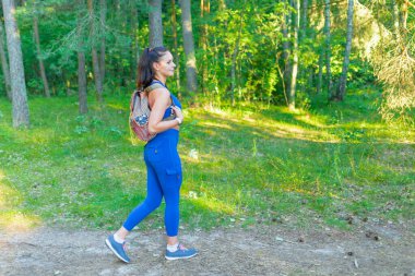 Sırt çantalı genç bir gezgin yaz ormanında yürüyor, seyahat tutkusu konsepti, kopyalama alanı.