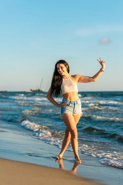 Piękna Seksowna Dziewczyna Plaży Morskiej Luźnych Ubraniach Patrzy Kamerę Zachodzie — Zdjęcie stockowe