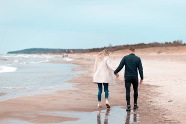 Sevgili çift kumsalda dinleniyor. Aşk konsepti tatili. Geriye bakış. Pring, sonbahar tatili..