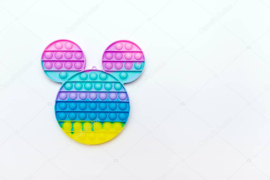 Color sensory pop it antistress toy for children. rainbow mickey mouse shaped on white background.Pop it trendy toy.Copy space.