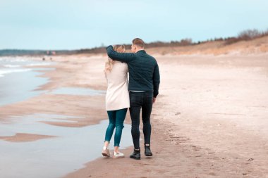 Sevgili çift kumsalda dinleniyor. Aşk konsepti tatili. Geriye bakış. Pring, sonbahar tatili..