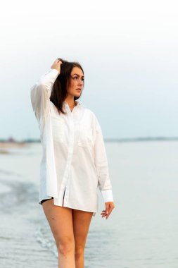 Beyaz gömlekli güzel bir kız. Deniz Tatili. Romantik Genç Kadın Mavi Doğal Arka plan Yazı Açık havada