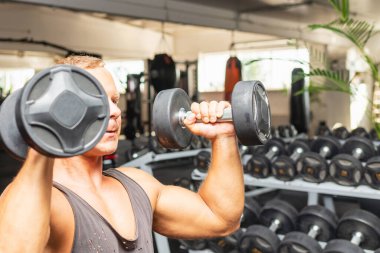 Spor salonunda aptal gibi egzersiz yapan genç bir adam. Sağlıklı bir adam aptallarla çalışıyor. Anlaşıldı..