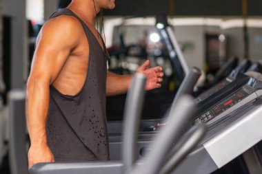 Spor giyimli genç bir adam spor salonunda koşu bandında koşuyor. Koşu bandında koşan yakışıklı bir sporcu. Kapalı alanda atış yapıyor. Koşu bandında spor salonunda koşuyor. Spor yapıyor..