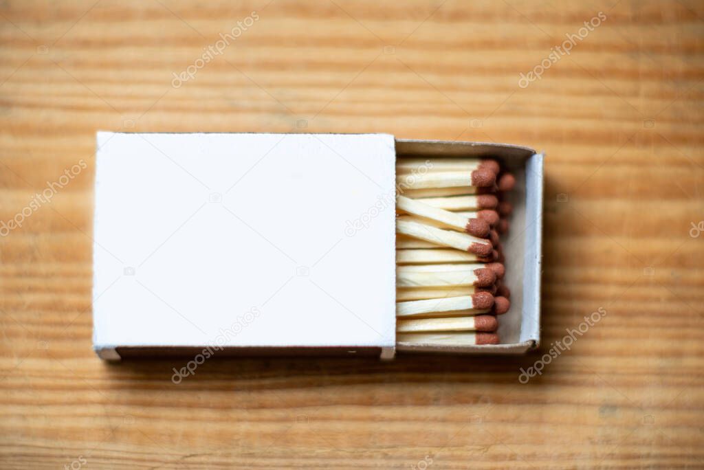 Cardboard box with matchsticks on a wooden background, blank space top view. Space for design,flat lay copy space for advertisement.Selective focus.