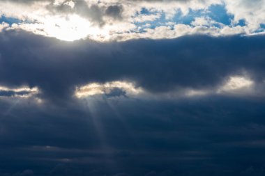 Karanlık bulutlar boyunca parlayan ışık ışınları. Güneş ışınları ile güzel dramatik gökyüzü. Dramatik gökyüzü ışınları..