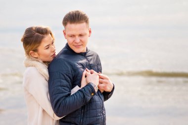 Genç çift sahilde eğleniyor ve eğleniyor. Bahar, sonbahar, sonbahar tatili..