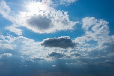 Bulutlar ve güneş ışınlarıyla dramatik mavi gökyüzü. Akşam günbatımında güneş ışınları..