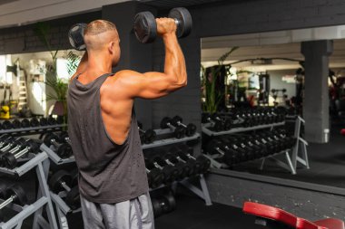 Spor salonunda aptal gibi egzersiz yapan genç ve formda bir adam. Sağlıklı bir adam aptallarla çalışıyor. Kapalı alanda çekim yapıyor..