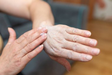 Kadının elleri cildine nemlendirici sürüyordu. Evde kadın el kremi sürmüş, yakından. Gençlik ve cilt esnekliği için bırakılmış kozmetik kremi olan eller. Kişisel bakım. minimalizm kavramı.