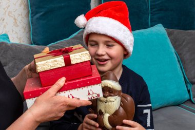 10 'lu yaşlardaki çocuklar ve anneleri evde Noel hediyeleri veriyorlar..