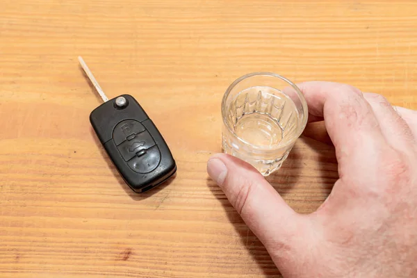 Drunk driving - the cause of car accidents. Hand reaches for car key and alcohol.Drink. Male hands and auto keys.