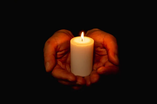 在黑暗中像心一样握住燃烧的蜡烛的手 有选择的焦点 黑色背景 — 图库照片