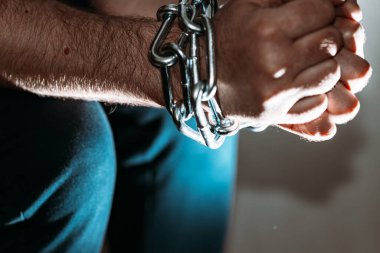 Zincirli zincire vurulmuş beyaz adam, hapis konsepti, suçlulara verilen ceza, insan ticareti, erkek ve kadınlara karşı şiddet..