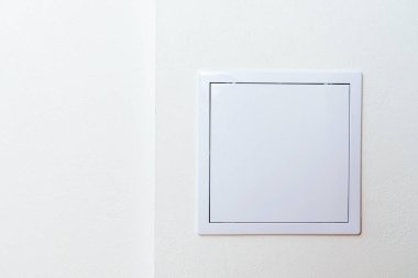 Beyaz bir duvardaki kare bir kapının maketi..