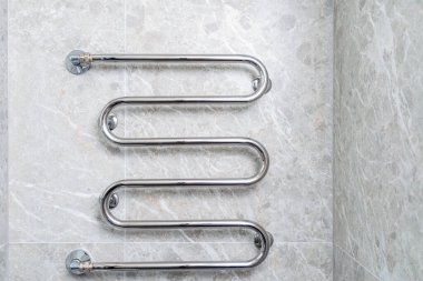 Gri taş bir duvarda banyo krom sıcak su ısıtıcısı..