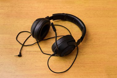 Masanın üstünde mikrofon olan siyah oyun kulaklığı..