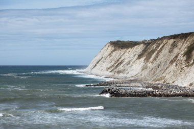 Rocky adası dağları, Bask Ülkesi 'nde okyanusun güzel mavisiyle buluşur. Deniz ve kayalar, arka plan olarak fotoğraf. Sahile yakın okyanus kıyısı manzarası..