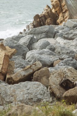 Fantastik büyük kayalar ve okyanus dalgaları. Sahilin yakınındaki bir kayanın arkasında dalga tepesi..