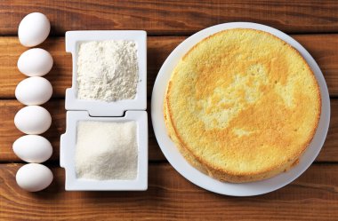 Yuvarlak ev yapımı bisküvi kek üzerine bir tabak, un, şeker ve yumurta