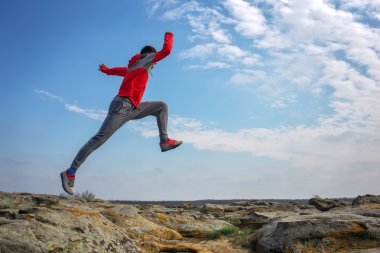 Çalışan, kayalar dağ bölgesinde üstünden atlayarak spor adamı. 