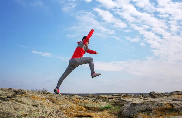 Sport homme courir, sauter par-dessus les rochers dans la région de montagne . — Photo