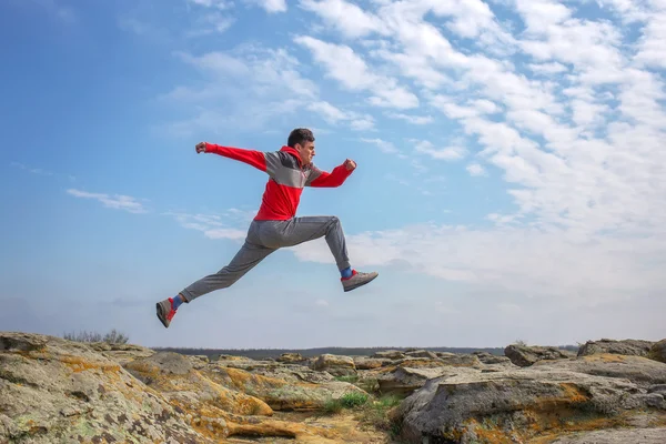 Sport homme courir, sauter par-dessus les rochers dans la région de montagne . — Photo