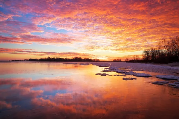 Hermoso paisaje de invierno con puesta de sol cielo ardiente y lago congelado —  Fotos de Stock