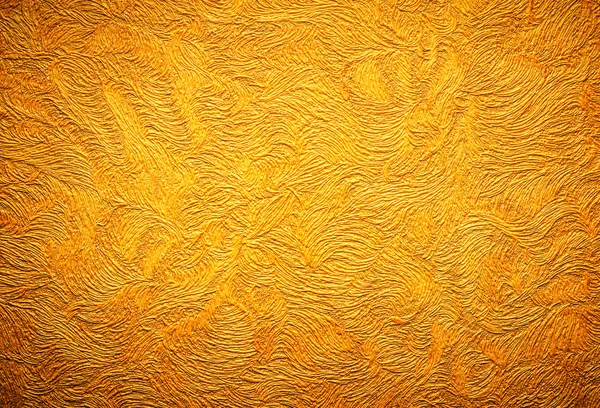 Gold background texture. Wallpaper on the wall.