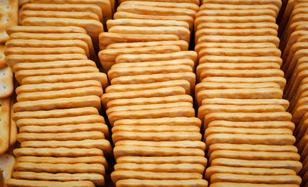 Dobrado em uma caixa de biscoitos quadrados saborosos como fundo — Fotografia de Stock