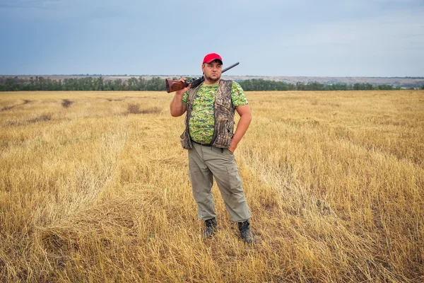 Hunter con un arma en el campo — Foto de Stock