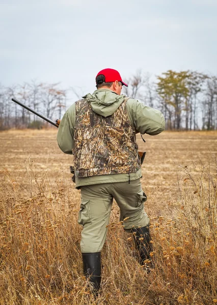 Hunter se déplaçant avec un fusil de chasse à la recherche de proies . — Photo