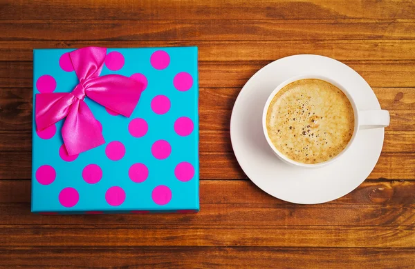 Große Geschenkschachtel und Tasse Kaffee auf Holzgrund. — Stockfoto