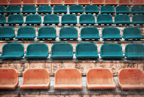 Açık kapı spor arena Stadyumu'nda boş eski plastik sandalye. 