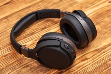 Ahşap bir arka planda müzik dinlemek ve oyun oynamak için kulaklık.