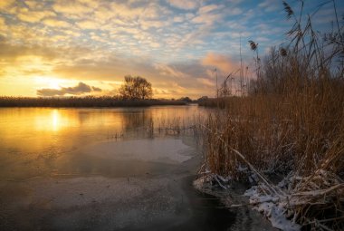 Kış manzarası, günbatımı gökyüzü ve donmuş nehir. Daybrea