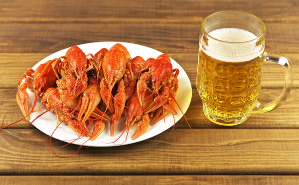 Sabroso cangrejo de río hervido y cerveza en una mesa — Foto de Stock