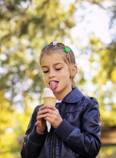 Красива маленька дівчинка їсть морозиво восени — стокове фото