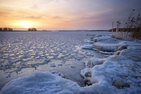 Beautiful winter landscape with frozen lake and sunset sky. — Stock Photo, Image