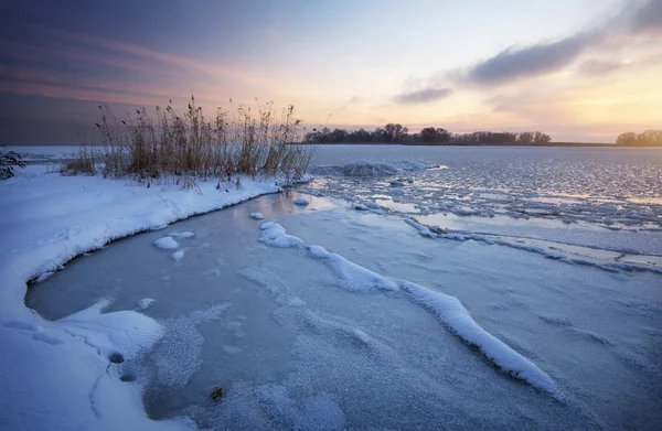 Krásná zimní krajina se zamrzlým jezerem a západem slunce. — Stock fotografie