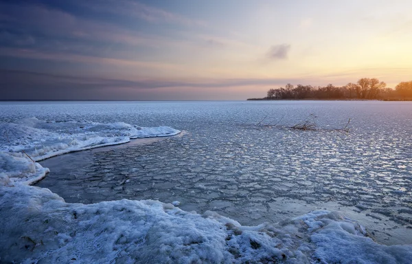 Krásná zimní krajina se zamrzlým jezerem a západem slunce. — Stock fotografie