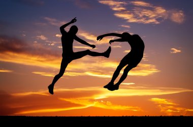 gün batımı ateşli zemin üzerine iki savaşçıları Silhouettes.