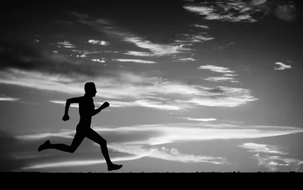Silhouette eines laufenden Mannes am bewölkten Himmel. schwarz-weiß. — Stockfoto