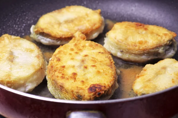 Trozos de pescado frito en una sartén con aceite vegetal — Foto de Stock