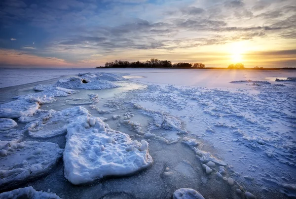 Paysage hivernal avec lac gelé et coucher de soleil. — Photo