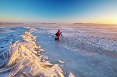 Fotoğrafçı kışın nehir kıyısında fotoğraf çekmek 