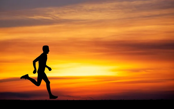 Silhouette of running man against the colorful sky. — Stock Photo, Image