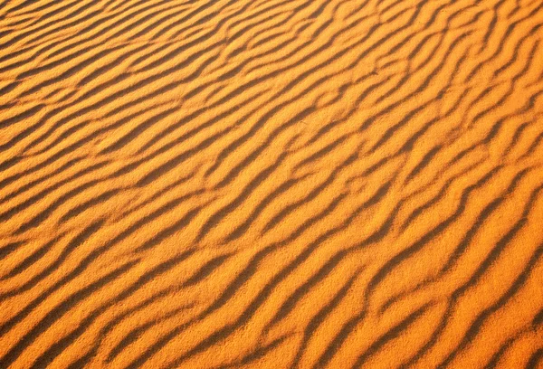 Piasek pustyni tło. Pustyni złotych na zachodzie słońca — Zdjęcie stockowe